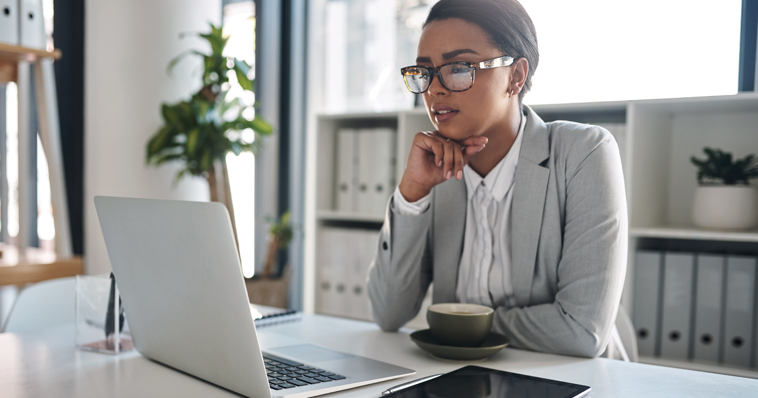 Woman at computer looking thoughtful